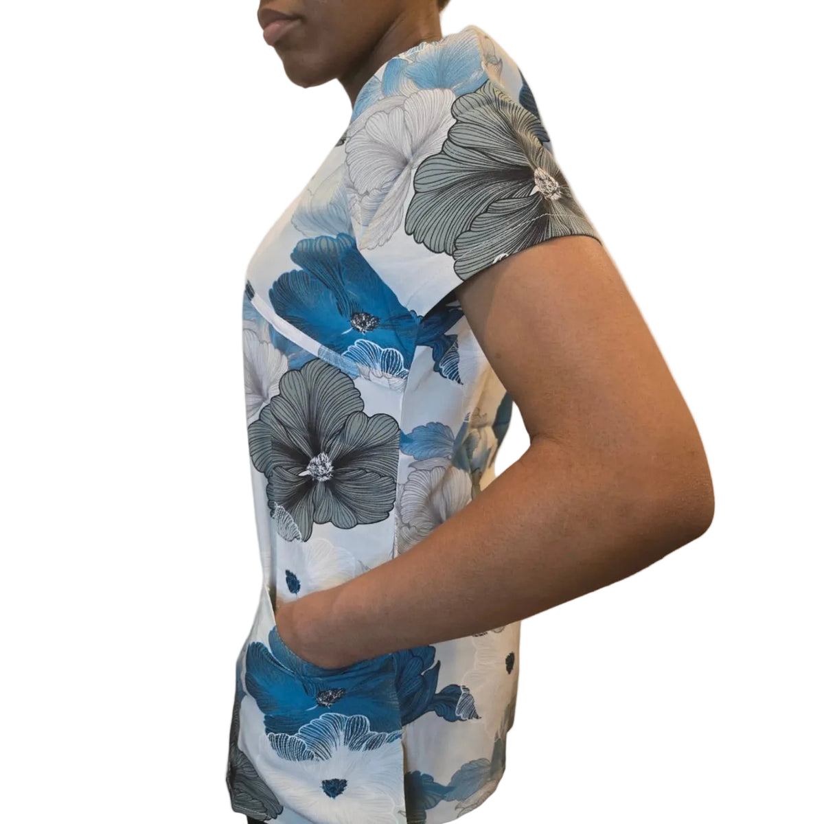 A person shown in side profile wearing a short-sleeve button-up shirt with a large floral print in blue, gray, and white on a light background.