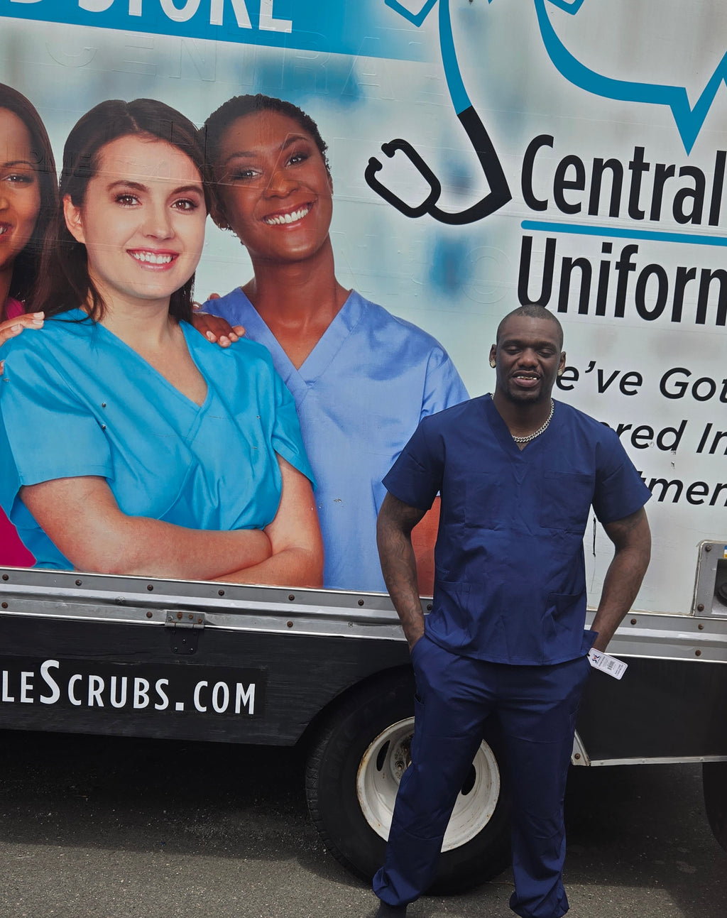 Person standing next to a vehicle with a Central Health Uniform advertisement on the side.